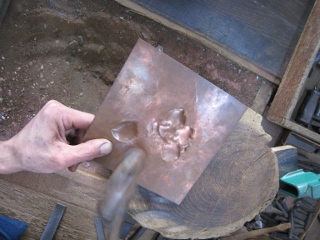 A professional metal-carver is embossing a design from the reverse side of the sheet. (provided by Choukin kougei Kikuhiro)